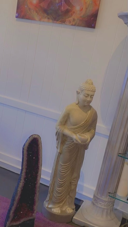 Buddha statue beside an amethyst geode in the shoppe