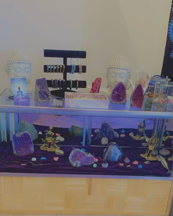 Amethyst geodes, buddha statues and chakra bracelets on display